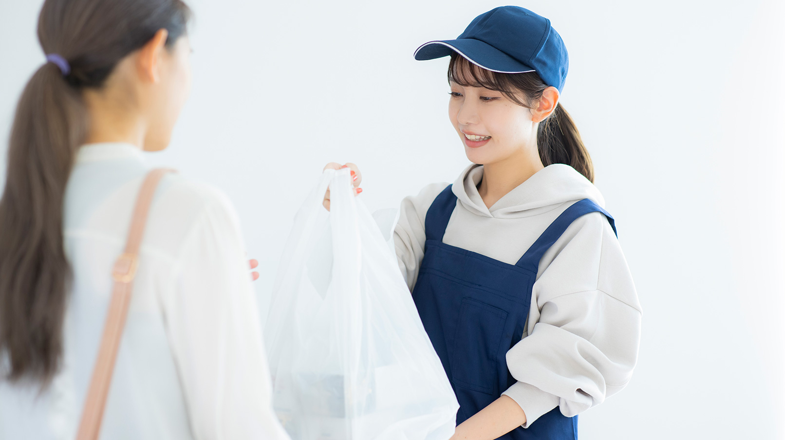 テイクアウトの商品を受け渡している女性スタッフ
