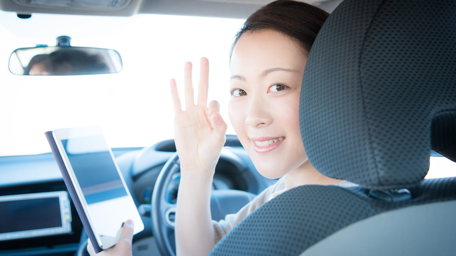車内で手でOKマークをしている女性