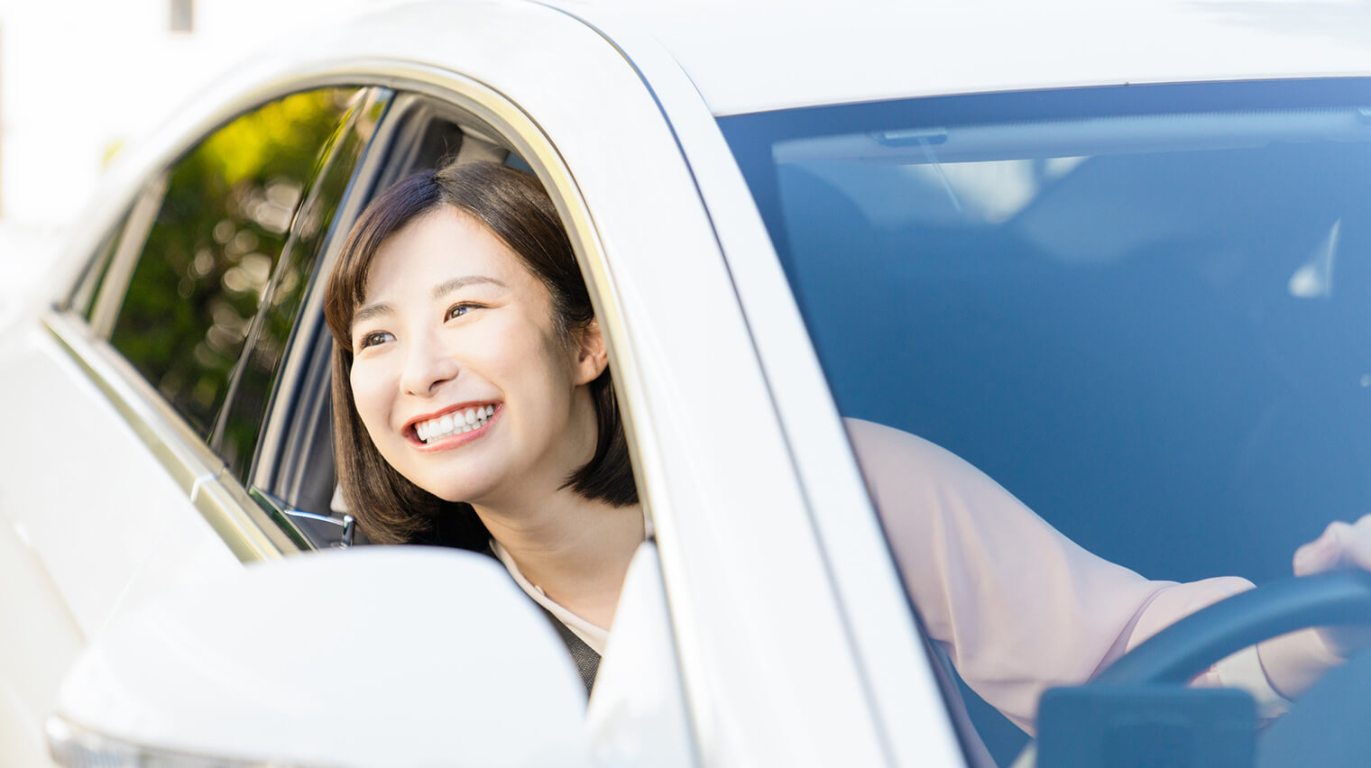 車から笑顔で顔を出す女性